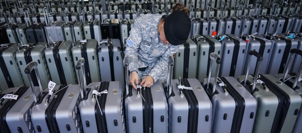 Una guardia revisa las etiquetas de las maletas que contienen los votos de los electores de Uruguay - Sputnik Mundo