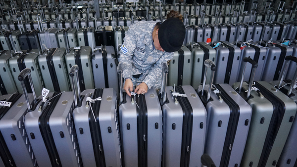 Una guardia revisa las etiquetas de las maletas que contienen los votos de los electores de Uruguay - Sputnik Mundo