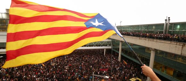 Un manifestante ondea la Estelada, la bandera independentista catalana, en Barcelona Un manifestante ondea la Estelada, la bandera independentista catalana, en Barcelona - Sputnik Mundo