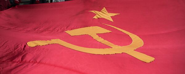 Bandera de la URSS en una marcha dedicada al aniversario de la Revolución de Octubre (2016) - Sputnik Mundo