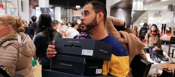 Работник в Мэйси несет коробки для покупателей во время Черную пятницы, Нью-Йорк - Sputnik Mundo