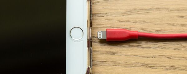 Un teléfono con cable de carga - Sputnik Mundo
