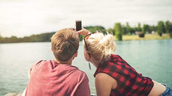 Una pareja haciendo selfi - Sputnik Mundo