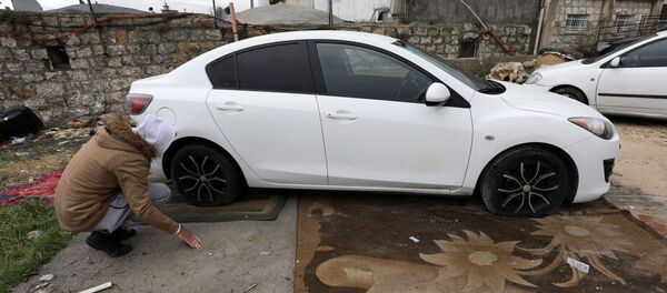 Un palestino examina su coche con los neumáticos rajados en Jerusalén Este - Sputnik Mundo