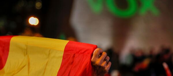La bandera de España con el letrero de Vox al fondo - Sputnik Mundo