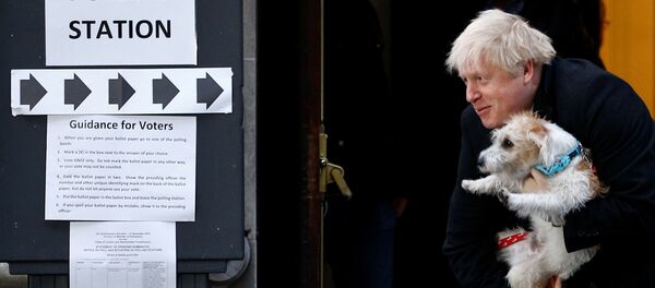 El primer ministro del reino Unido, Boris Johnson, sale de un colegio electoral con su perro Dilyn - Sputnik Mundo