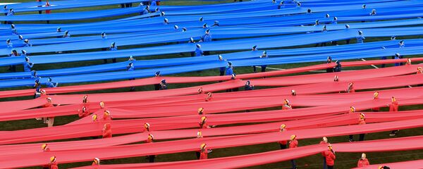 Escolares rusos apoyan los deportistas del país con una bandera de 100 metros - Sputnik Mundo
