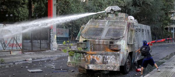 Un carro lanzaguas durante una protestas en Santiago, Chile Un carro lanzaguas durante una protestas en Santiago, Chile - Sputnik Mundo
