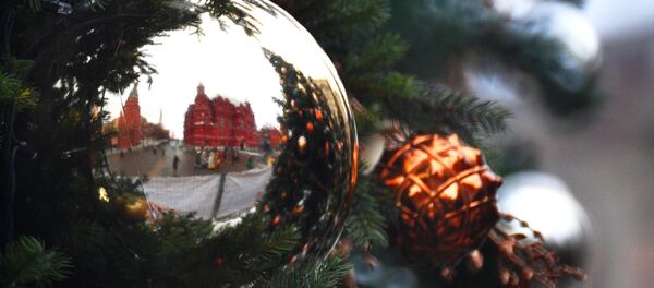Los muros de la Plaza Roja de Moscú reflejados en un adorno navideño - Sputnik Mundo