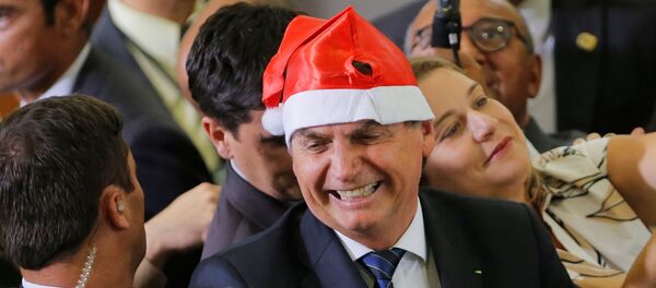 El presidente de Brasil, Jair Bolsonaro, usando un sombrero de Navidad - Sputnik Mundo