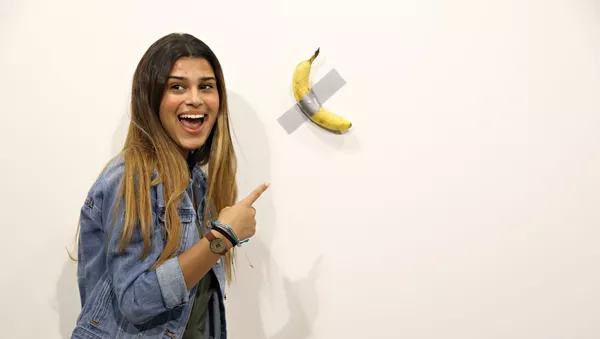Una visitante de la exposición al lado de la obra 'Comediante' del artista italiano Maurizio Cattelan