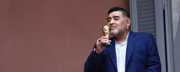 El exfutbolista Diego Armando Maradona besa una réplica de la Copa del Mundo en el balcón de la Casa Rosada - Sputnik Mundo