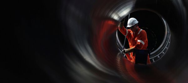 Un trabajador es visto a través de una tubería en el sitio de construcción del gasoducto Nord Stream 2 en Rusia - Sputnik Mundo