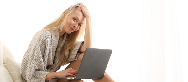 Una mujer utiliza su computadora en la cama - Sputnik Mundo