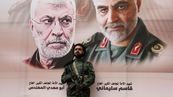 Un militar con el fondo del retrato del general Soleimani - Sputnik Mundo