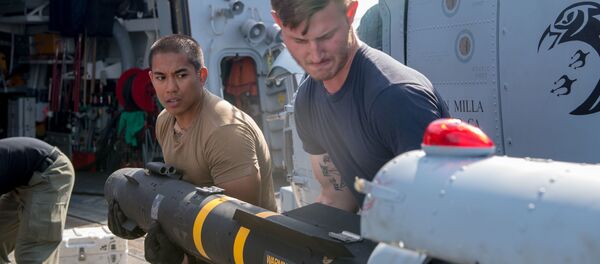 Los soldados de la Marina de EEUU cargan un misil Hellfire AGM-114 en un helicóptero - Sputnik Mundo