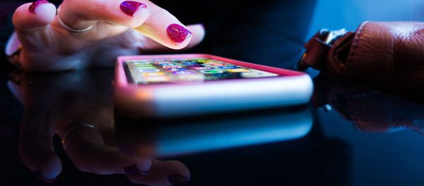 Una mujer utiliza su teléfono móvil Una mujer utiliza su teléfono móvil - Sputnik Mundo