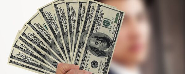 Una persona con varios billetes de cien dólares - Sputnik Mundo