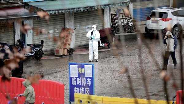 Un empleado vestido con un traje protector en Wuhan, China Un empleado vestido con un traje protector en Wuhan, China - Sputnik Mundo