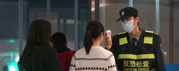 Проверка пассажиров в аэропорте китайского города Ухань - Sputnik Mundo