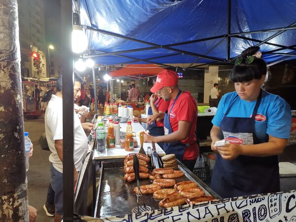 El famoso choripan a la venta en cada esquina de 18 de julio, una de las comidas típicas del carnaval uruguayo junto con la famosa torta frita - Sputnik Mundo