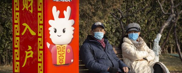 Personas con mascarillas en un parque de Pekín, China - Sputnik Mundo