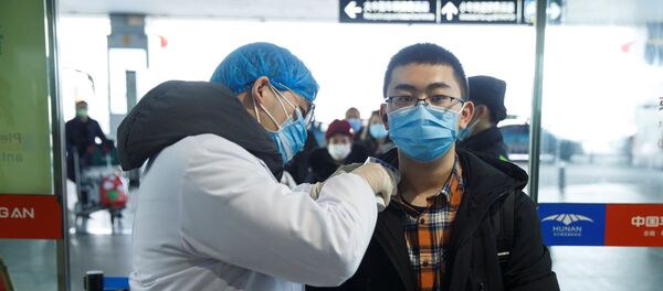 Un chino durante la revisión para detectar el coronavirus - Sputnik Mundo