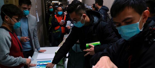 Unos chinos que llevan mascarillas para protegerse del coronavirus Unos chinos que llevan mascarillas para protegerse del coronavirus - Sputnik Mundo