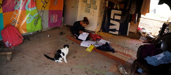 Una chica en su tienda familiar haciendo sus tareas - Sputnik Mundo