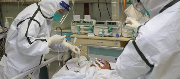 El personal médico trata a un paciente en Wuhan, China - Sputnik Mundo