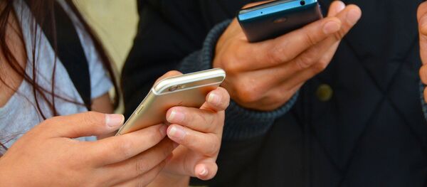 Unas personas con unos teléfonos móviles - Sputnik Mundo