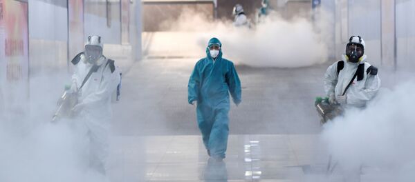 Un voluntario con un traje de protección en China - Sputnik Mundo