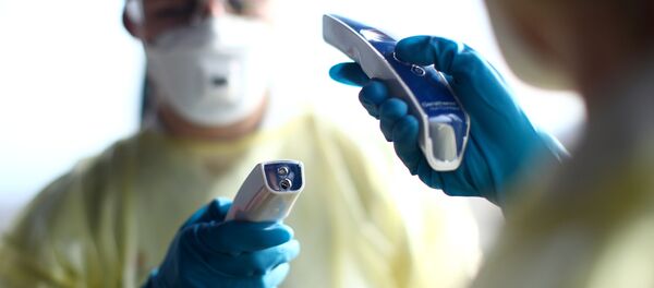 Miembros de la Cruz Roja con termómetros - Sputnik Mundo