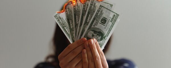 Dólares estadounidenses en llamas (imagen referencial) - Sputnik Mundo