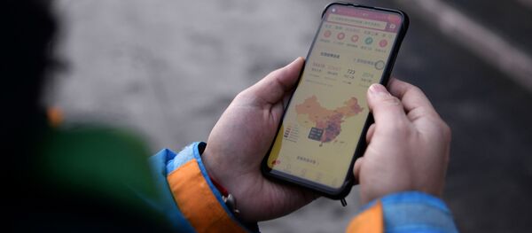 Un teléfono con el mapa de riesgo por contagio del coronavirus - Sputnik Mundo