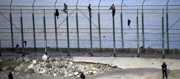 Migrantes en la valla fronteriza que separa la ciudad autónoma española de Ceuta de Marruecos - Sputnik Mundo