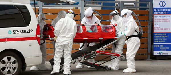 Médicos en Corea del Sur atienden a una persona contagiada con el coronavirus - Sputnik Mundo