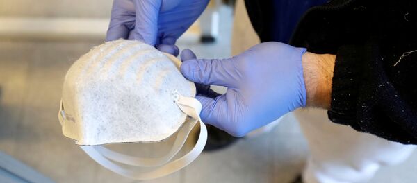 Hombre con mascarilla en sus manos - Sputnik Mundo