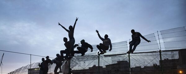 Inmigrantes subsaharianos trepan por la valla de Melilla Inmigrantes subsaharianos trepan por la valla de Melilla - Sputnik Mundo