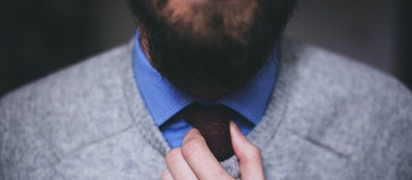 Un hombre con barba ajusta su corbata Un hombre con barba ajusta su corbata - Sputnik Mundo