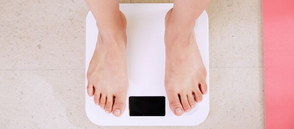 Pies de una persona en una báscula (imagen referencial) - Sputnik Mundo