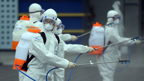 Personas con trajes protectores Personas con trajes protectores - Sputnik Mundo