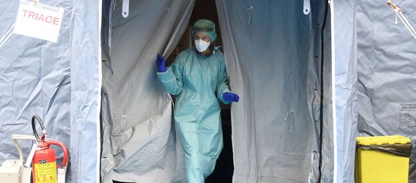 Personal médico en un traje protector y una mascarilla - Sputnik Mundo