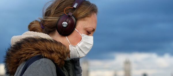 Una muchacha lleva una mascarilla puesta (archivo) - Sputnik Mundo