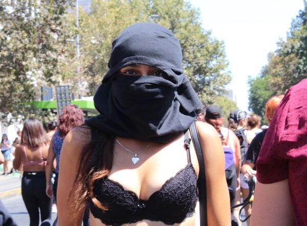 Una joven con capucha en la marcha del 8M en Santiago de Chile - Sputnik Mundo