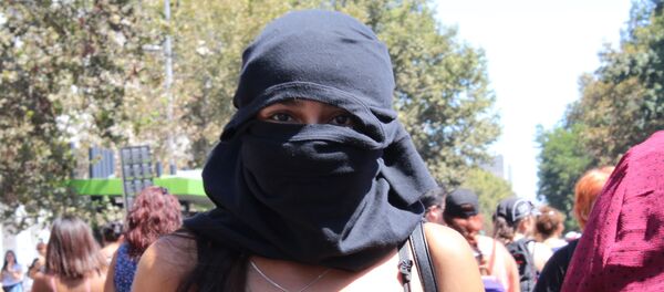 Una joven con capucha en la marcha del 8M en Santiago de Chile - Sputnik Mundo