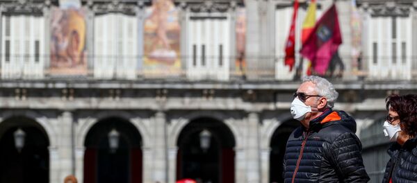 Dos personas con mascarillas en la Plaza Mayor de Madrid - Sputnik Mundo