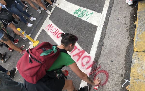 Una mujer pintando una consigna en la calle durante la marcha del 9M en Buenos Aires, Argentina - Sputnik Mundo