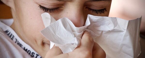 Un niño estornudando y con un pañuelo. Imagen referencial - Sputnik Mundo