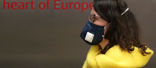 Una mujer con mascarillas en Bruselas Una mujer con mascarillas en Bruselas - Sputnik Mundo